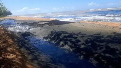 TURISMO? Areia preta em praia de Manguinhos