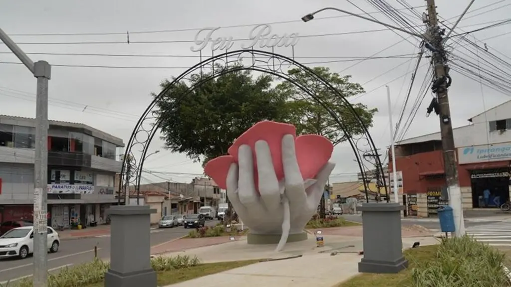 Escultura mão com rosa transforma entrada do bairro Feu Rosa