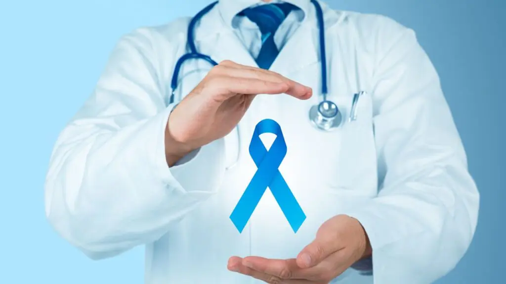 Novembro Azul: Serra terá ação especial voltada para homens no AMES em Jardim Limoeiro Médico segurando laço da campanha Novembro Azul