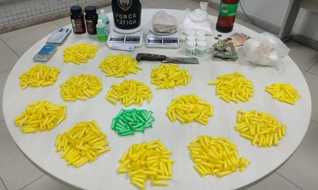 Polícia Militar prende mulher com mais de 700 pinos de cocaína em Cariacica Sobre a uma mesa redonda da Policia Militar 702 pinos e 630 gramas de cocaína, 545 gramas de crack e quatro balanças de precisão e produtos para refino das drogas
