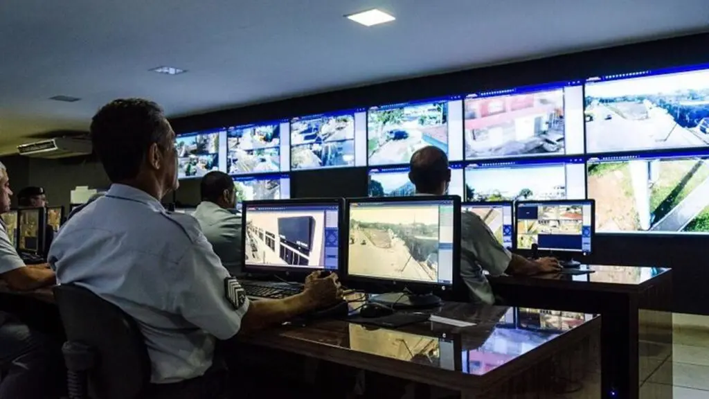 Polícia Militar detém homem e recupera veículo roubado durante “Test Drive” na Serra Central do Cerco Inteligente, agentes trabalhando com vários monitores com imagens de várias localidades da Serra