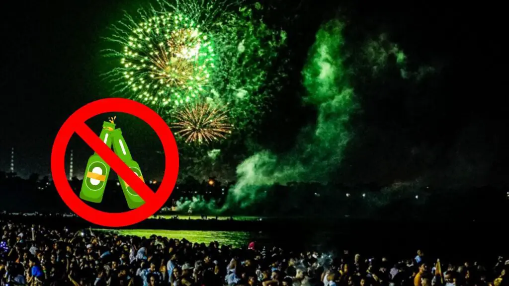 Réveillon em Vitoria terá limitação na venda de bebidas em garrafas de vidro nos quiosques Foto da queima de fogos em praia de Vitória com uma arte de proibido com duas garrafas de cervejas