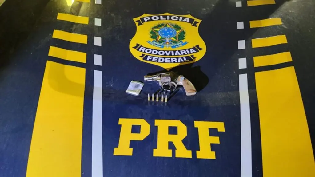 GTA Serra: PRF prende motorista dirigindo armado e alucinado de cocaína na BR-101 Sobre o capo de uma viatura da Polícia Rodoviária Federal, um revólver 5 munições e um papelote de cocaína