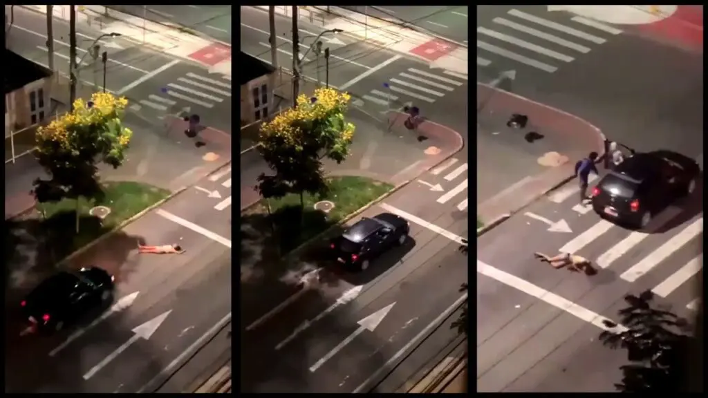 Vídeo: mulher se deita na rua durante briga com companheiro e acaba atropelada em Vitória Imagem de um automóvel aproximando de uma mulher deitada no meio da rua em Vitória