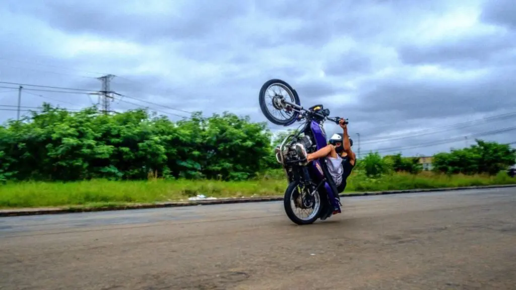 Dando um grau? Saiba quanto isso pode doer no seu bolso em caso de multas Motociclista empinando a moto