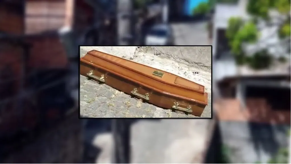 Caixão com defunto aparece no meio da rua e assusta moradores de Vila Velha Arte com uma foto centralizada com um caixão no meio de uma rua, e ao fundo um bairro de Vila Velha desfocado
