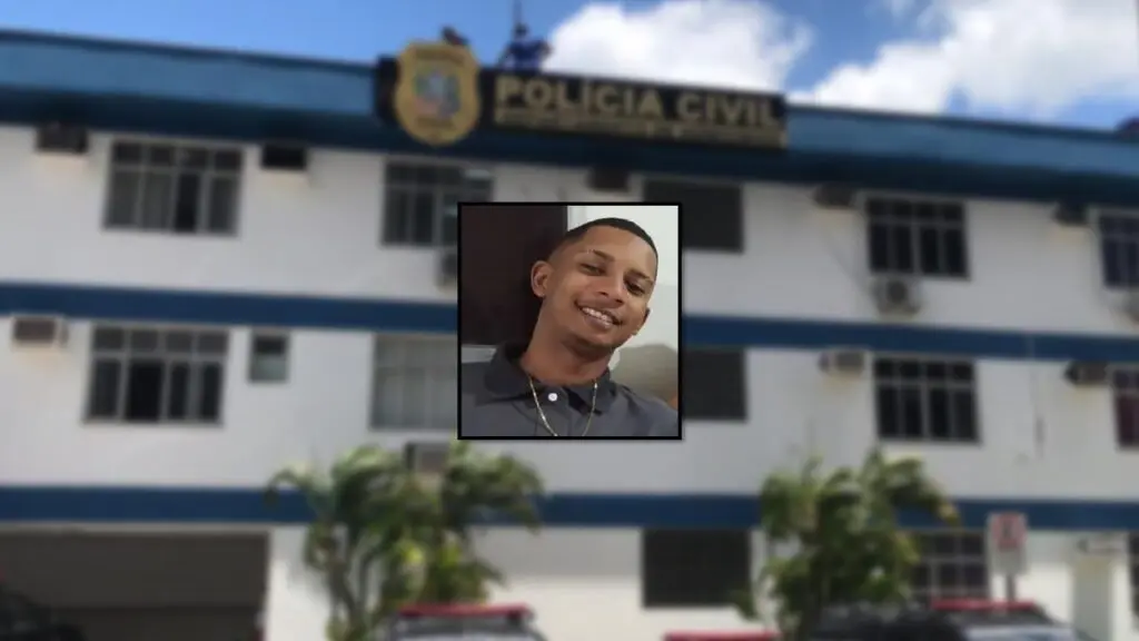 Jovem é assassinado a tiros enquanto dormia ao lado do filho de 5 anos na Grande Vitória Arte com foto de jovem de 26 anos morto, enquanto dormia ao lado de filho de 5 anos, ao fundo um prédio sede do Departamento de homicídios da Policia Civil