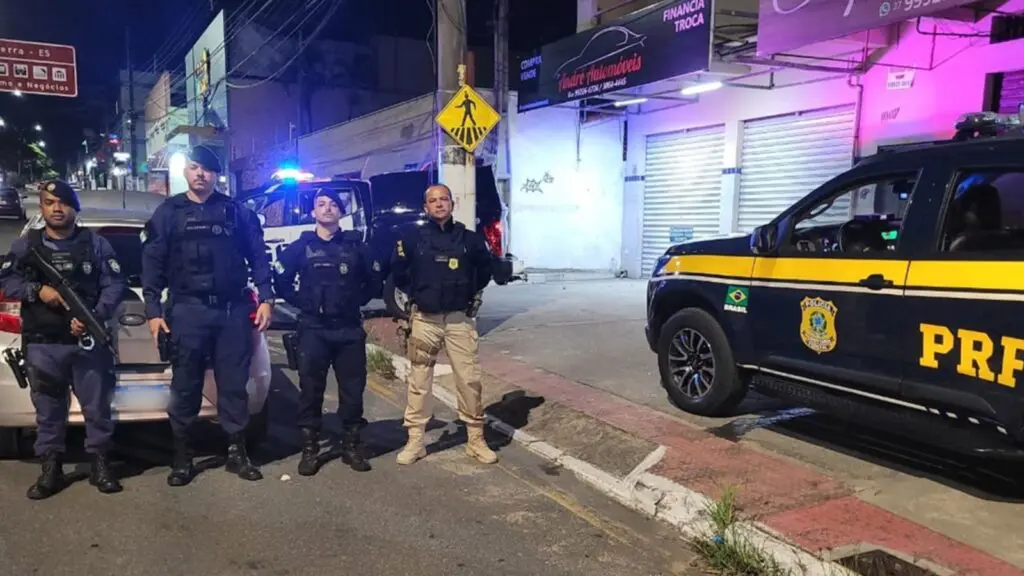 Agentes da Guarda Civil Municipal e da PRF em frente ao carro apreendido