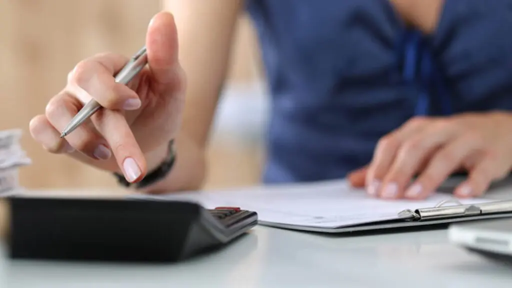5 dicas de como começar a organizar sua vida financeira Foto de uma pessoa calculando as finanças pessoais