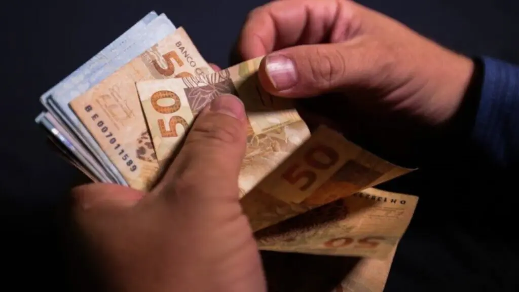 Foto de uma pessoa contando a renda extra