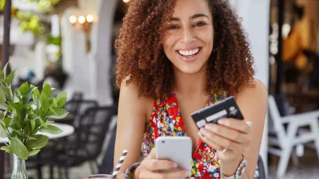 Como funciona o limite emergencial de crédito e quando utilizar Foto de uma moça segurando um cartão de crédito