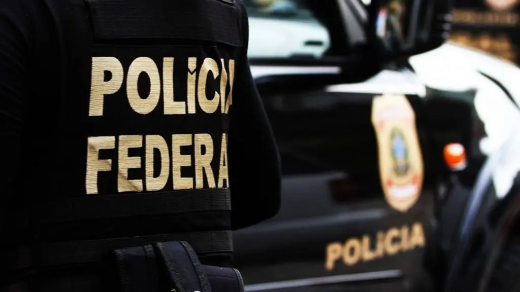 Operação da Polícia Federal mira grupos extremistas ligados ao ataque em escola de Aracruz Foto de um agente da Polícia Federal de costas com um destaque em o nome da Polícia Federal do seu uniforme
