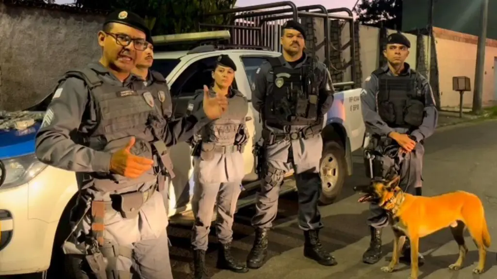 PM é chamada para resolver treta de inquilino e acaba detonando biqueira recheada de maconha em Jacaraípe Foto do Sargento Mauricio Sousa apresentando outros 4 policiais militares que estão parados em frente a uma viatura da Policia Militar e junto com os militares o cão farejador Apollo.