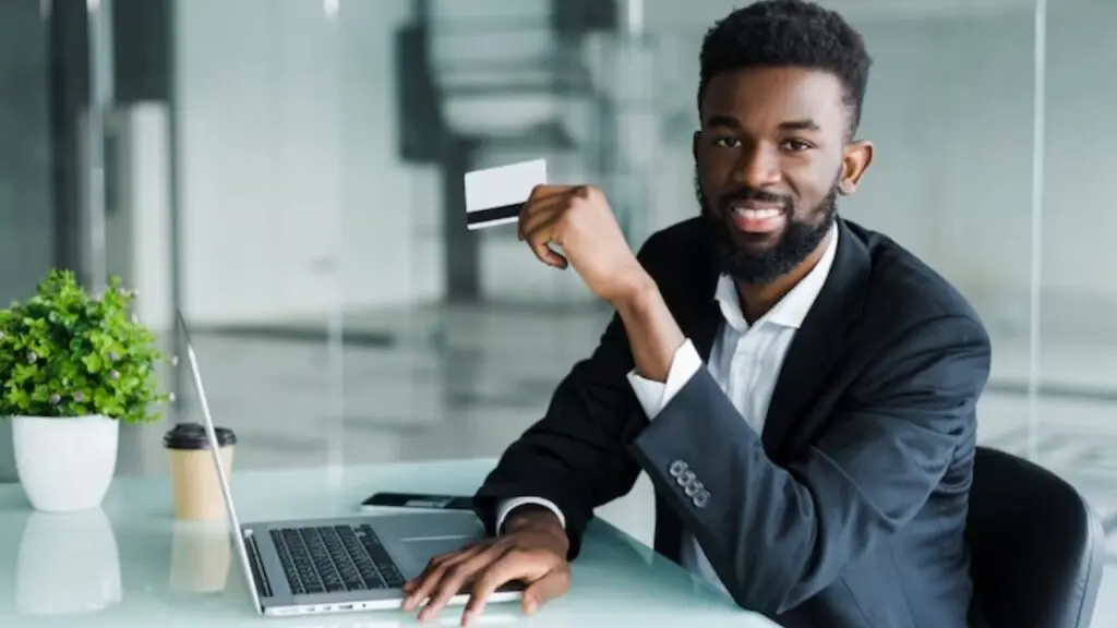 Foto de uma pessoa segurando um cartão de crédito
