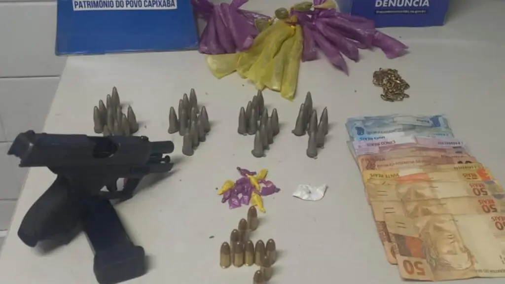 Gerente do tráfico do Planalto Serrano é preso pela Polícia Militar após denúncias anônimas Sobre uma mesa branca uma pistola calibre 9mm com um carregador contendo 11 munições intactas, 38 pinos de cocaína, um papelote pequeno de cocaína, 19 buchas de maconha, três buchas pequenas de maconha, 14 pedras de crack e 314 reais em espécie.