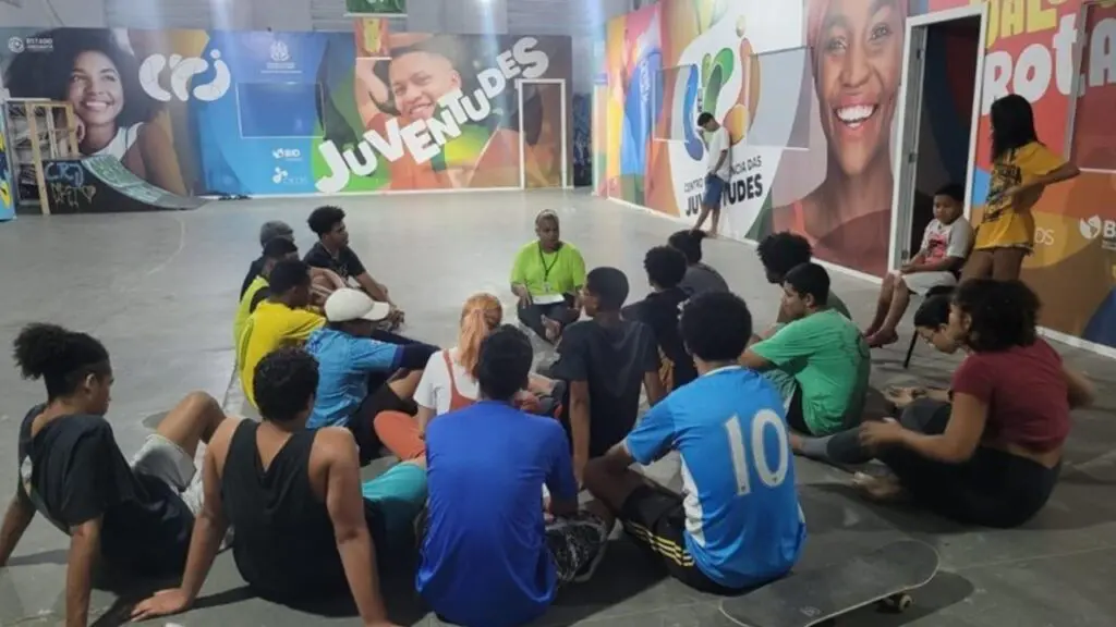 Centro de Referência das Juventudes Novo Horizonte abre vaga para Educador Social Foto do ambiente do CRJ, jovens reunidos em torno do educador social
