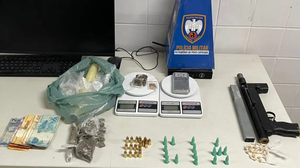 Polícia Militar prende vapor recheado de flagrantes em Nova Carapina Material apreendido com traficante durante a prisão, sobre a mesa dinheiro em espécie, 27 pedras de crack, 16 pinos de cocaína, 29 buchas de maconha e três buchas de haxixe.