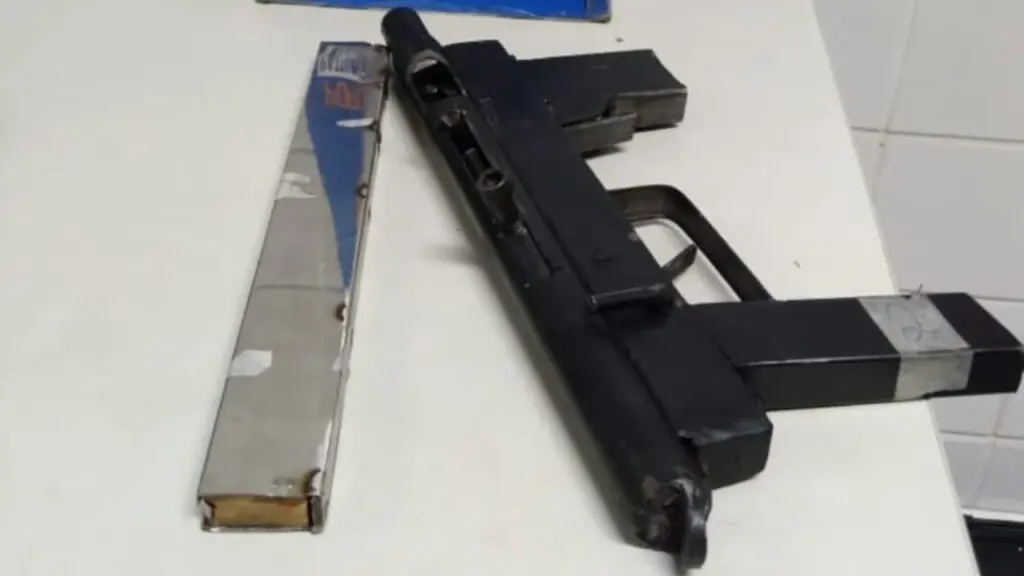 Polícia Militar captura homem e apreende metralhadora craftada na Serra Sobre uma mesa da delegacia, uma Submetralhadora de fabricação caseira, e um pente alongado.