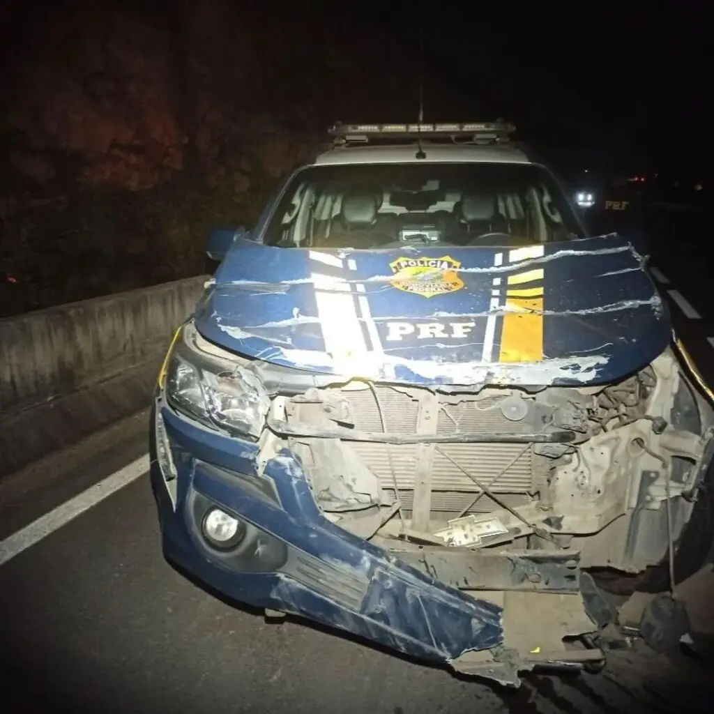 viatura da PRF, com a parte frontal destruída, após o caminhão atingir o veículo