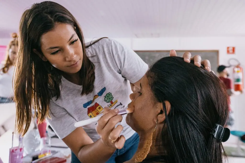 Maquie&Crie abre projeto com 150 vagas de maquiagem e figurino para jovens na Serra Uma jovem maquinhando uma mulher