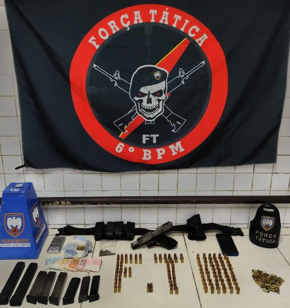Materiais apreendidos durante a ação da Força Tática que resultou na prisão de Moizes Viana, sobre uma bancada: 127 munições calibre 45, 13 munições calibre 9mm, 18 munições calibre 380, duas munições calibre .40, R$954 em dinheiro, uma balança de precisão e um celular. 