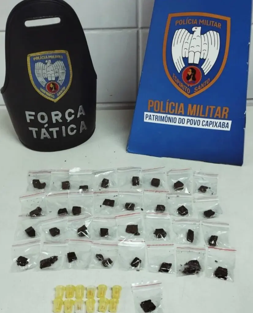 Materiais apreendidos pela Força Tática sobre uma mesa 33 buchas de maconha, 12 pedras de crack, além de R$24,00 em dinheiro.
