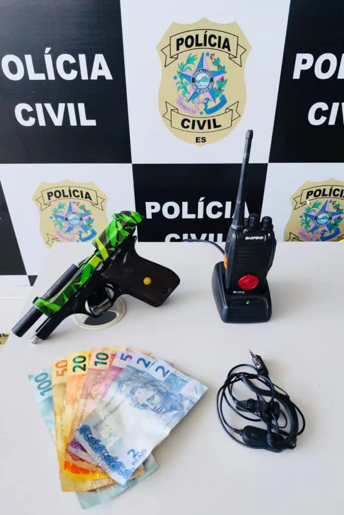 Sobre uma mesa uma pistola calibre .380 um rádio comunicador e 189 reais em espécie.