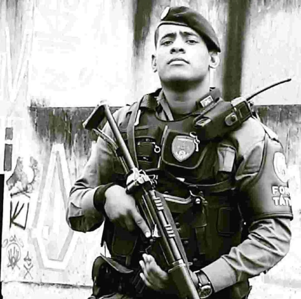 Um policial militar fardado segurando uma metralhadora (Jefferson Pratis da Costa Nunes, de 35 anos)