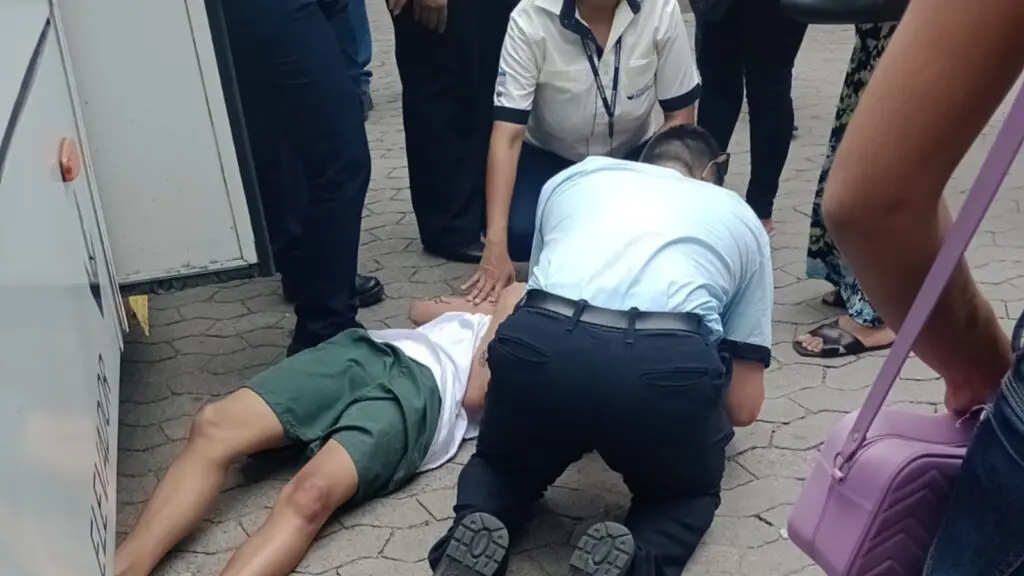 A vítima sendo socorrida por funcionários da empresa de ônibus.