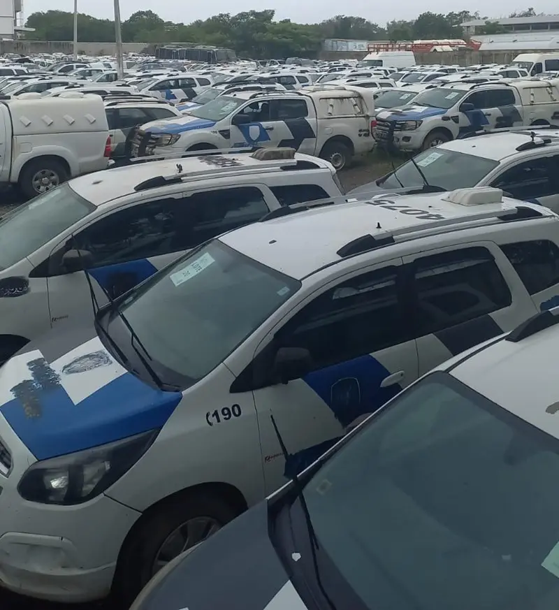 Imagem de um patio com diversas viaturas da Polícia Militar estacionadas que serão leiloadas.