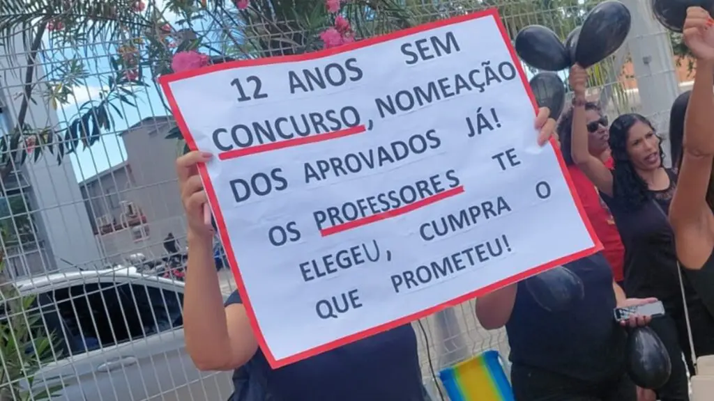 Professores aprovados no concurso protestam em frente à Prefeitura da Serra, segurando cartazes e exigindo convocação.