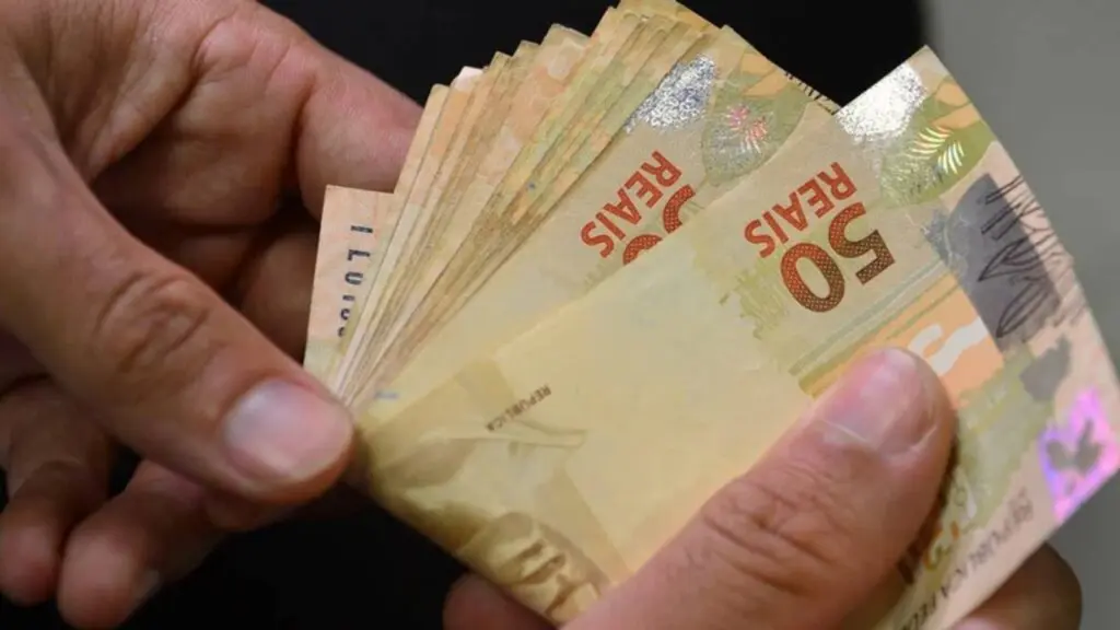 Saiba como vai funcionar o crédito consignado CLT Homem contando dinheiro (notas de 50 reais)