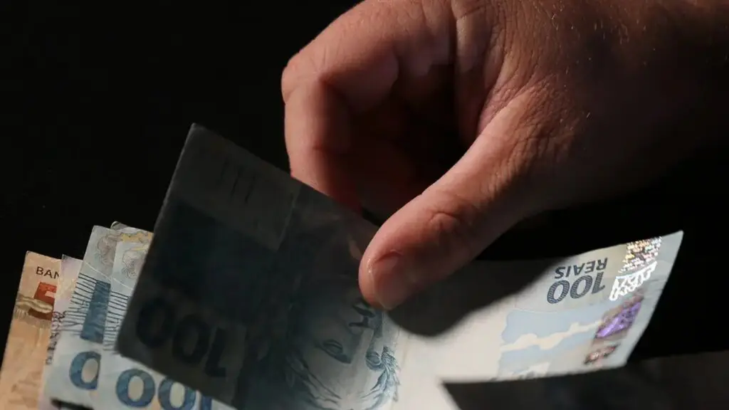 Novo crédito consignado para trabalhadores CLT entra em vigor no Brasil; veja como funciona contando notas de reais