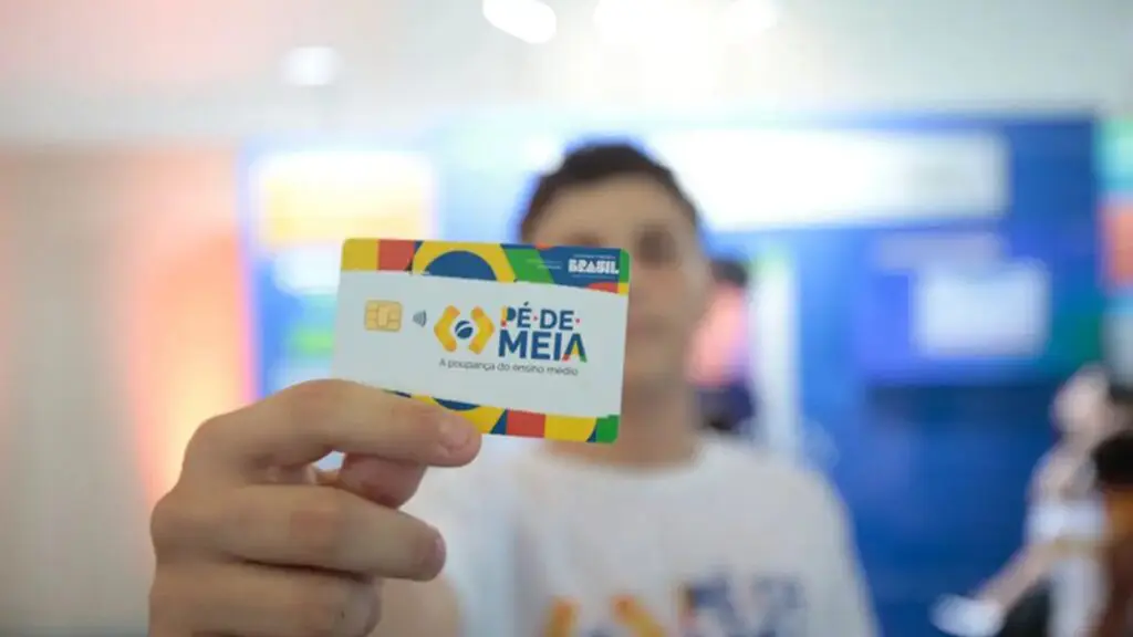 Aluno segurando o cartão do Pé-de-meia do governo federal