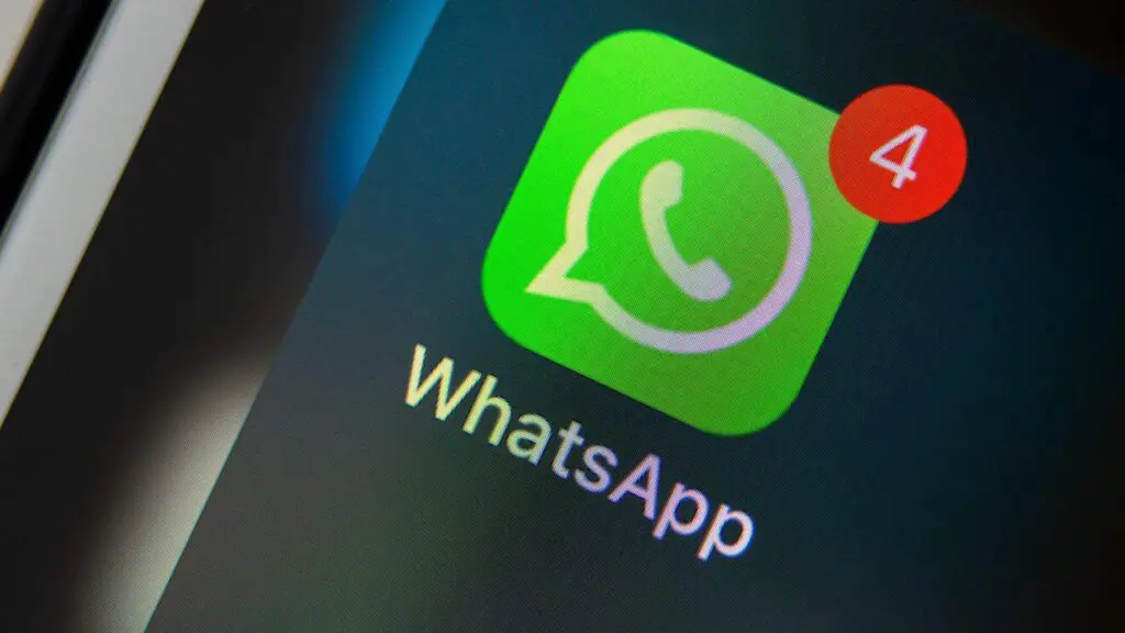 Veja os 10 golpes mais aplicados contra clientes bancários em 2024 Celular com tela do WhatsApp aberta ao lado de cartão bancário, representando golpes digitais contra clientes de bancos