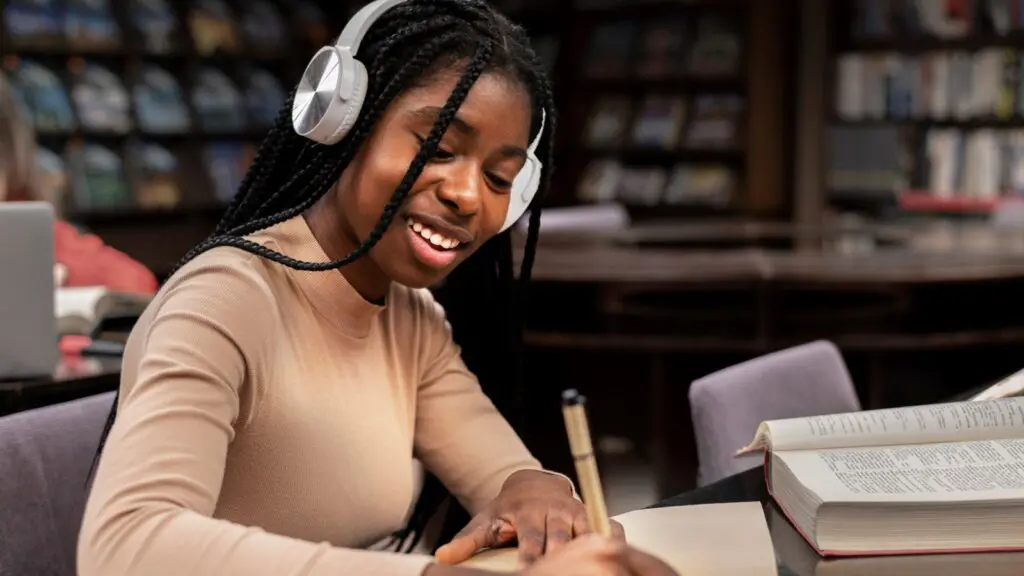 Programa oferece até R$ 35 mil em bolsas para estudantes negros Mulher negra estudando em uma biblioteca.