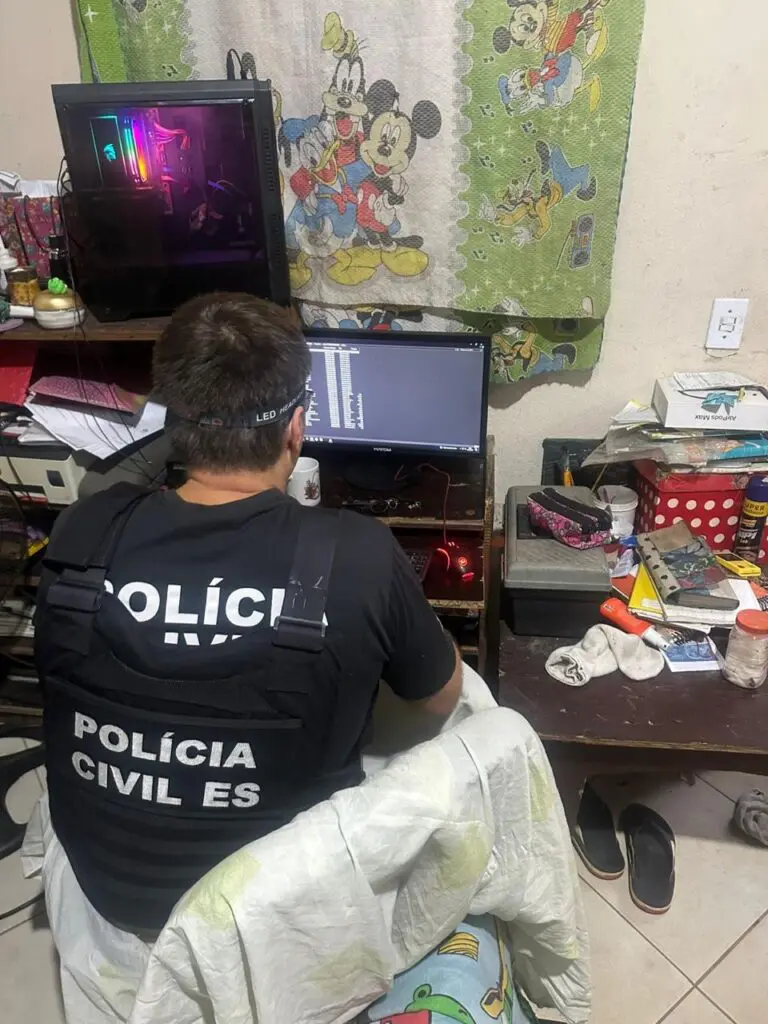 Um investigador analisando o computador do adolescente durante uma operação da Polícia Civil.
