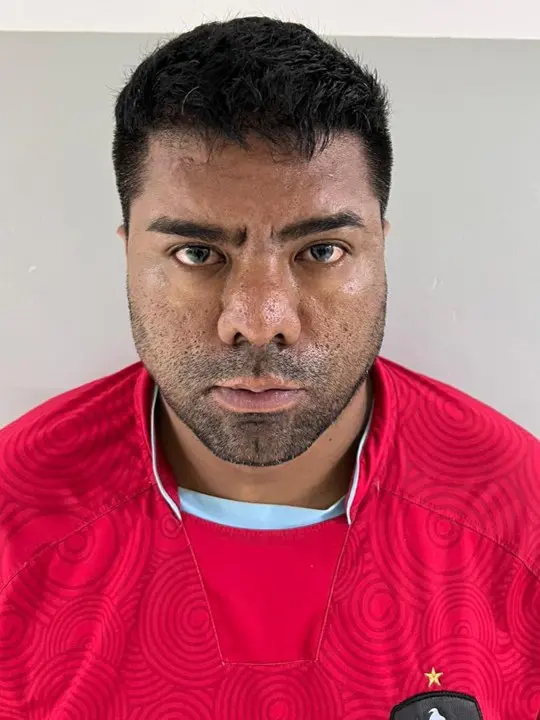 Foto de um homem (Maikon Ferraz Gonçalves, 35 anos), com as mãos para trás preso por fazer parte de uma quadrilha que furtou diversas instituições financeiras em vários estados do Brasil.