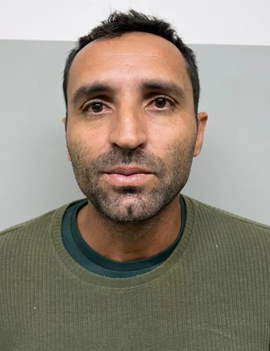 Foto de um homem (Paulo Cezar Teotônio da Silva, 39 anos), com as mãos para trás preso por fazer parte de uma quadrilha que furtou diversas instituições financeiras em vários estados do Brasil.