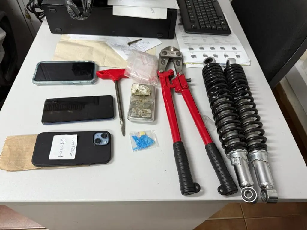 Sobre uma mesa celulares, drogas um alicate de cortar vergalhão, molas de uma motocicleta, que foram apreendidas pela Polícia Civil.
