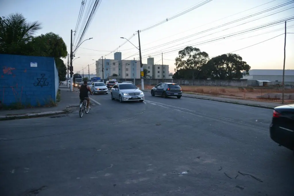 Imagem de uma avenida com carros trafegando em duas pistas em direções diferentes.