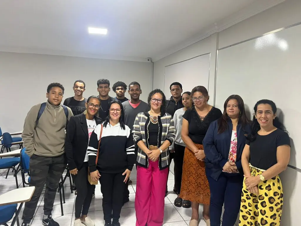 Cerca de 10 pessoas em uma sala de aula posando para uma foto.