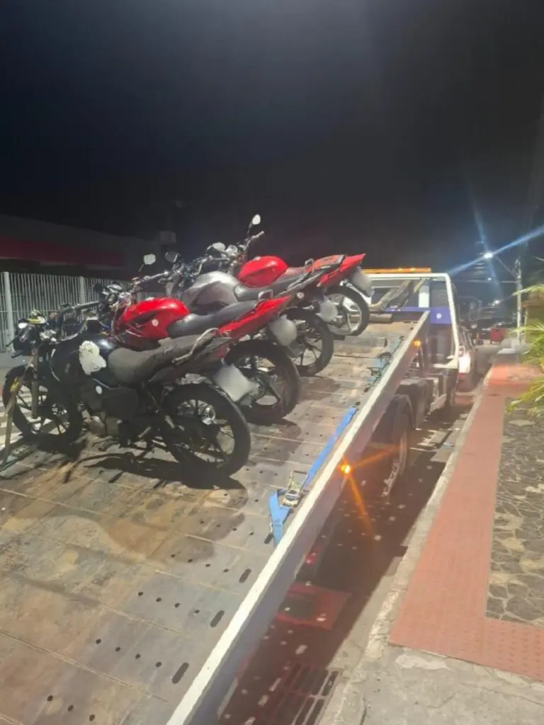 Quatro motocicletas apreendidas colocadas em um caminhão guincho.