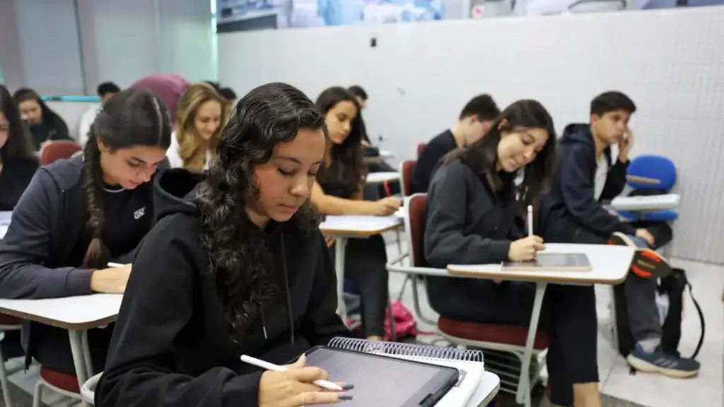 Estudantes assistindo aula em universidade privada