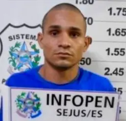 Imagem de um homem (Diego Ferreira de Paula) em frente a uma parede com marcações de altura. 