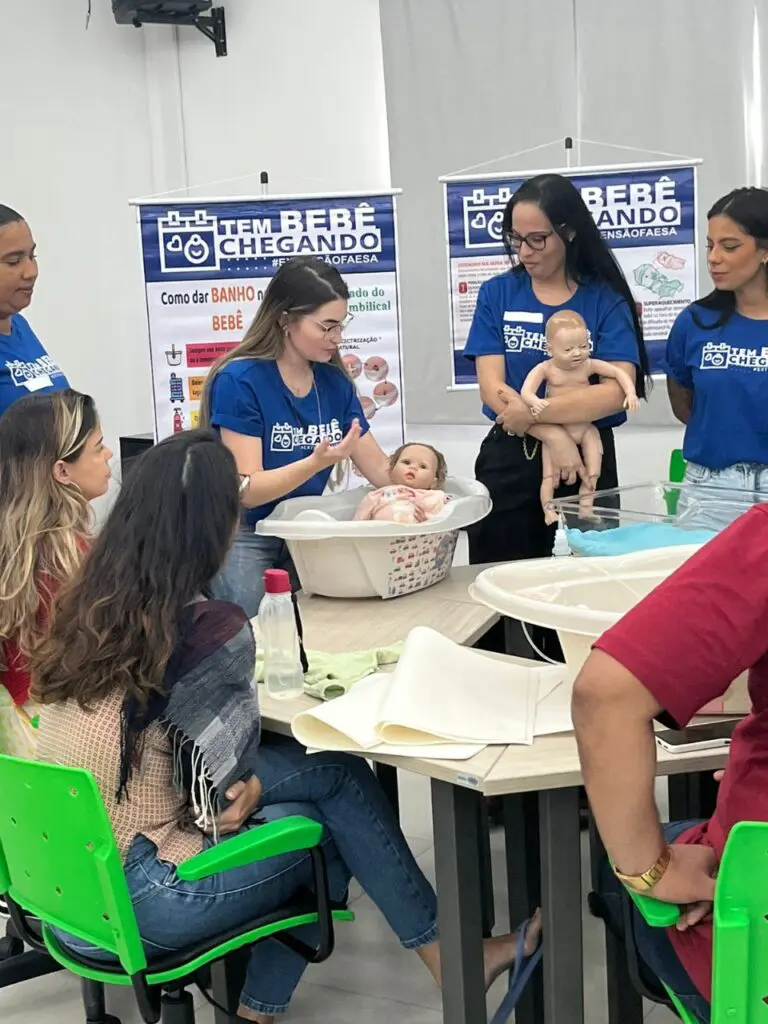 Alunas e orientadoras participam de uma das aulas sobre higiene do bebê, aprendendo a dar banho em bebês, usando bonecos.