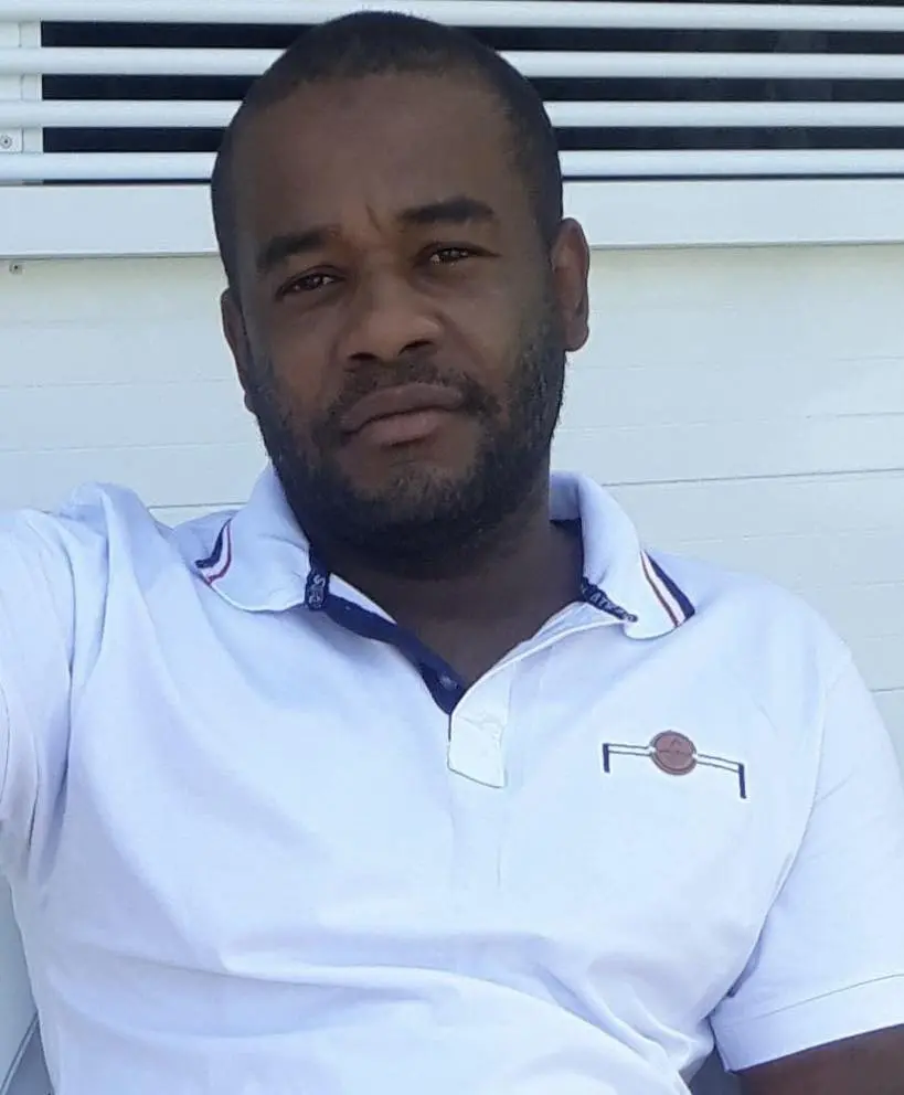 Imagem de um homem de camiseta polo posando para a foto.