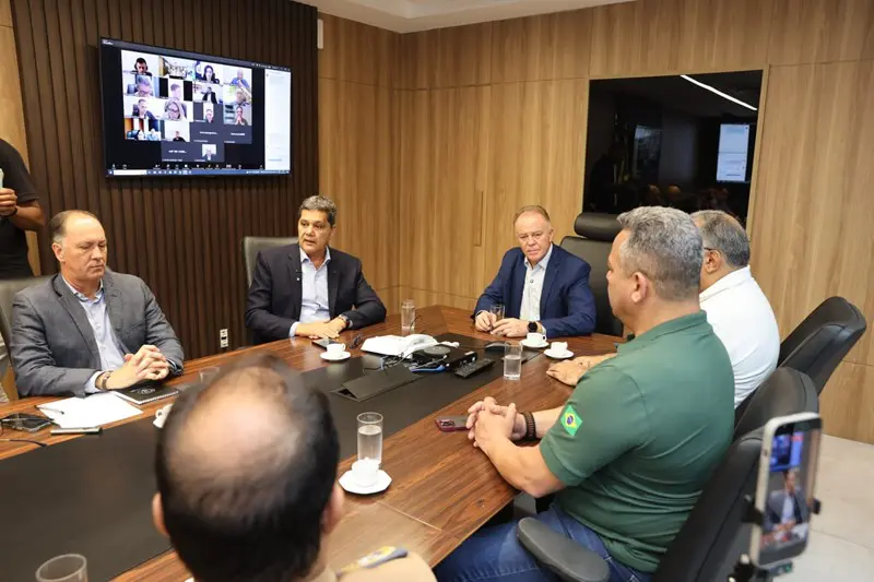 Imagem de uma sala de reunião com o governador Renato Casagrande e outras autoridades discutindo o plano de contingência de segurança no ES.