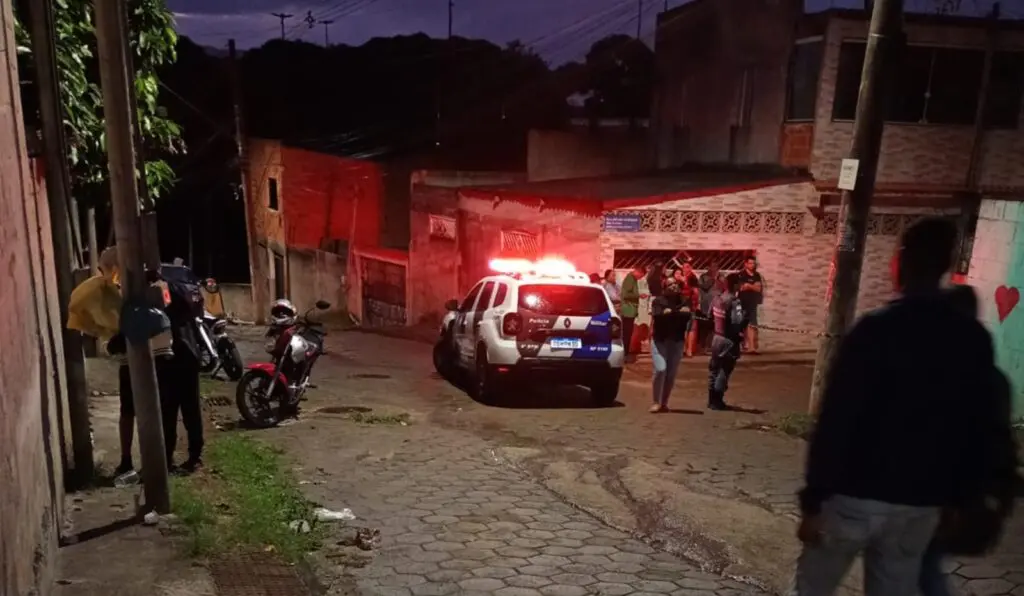 Local do homicídio na Rua Alfredo Rodrigues dos Santos, cercado por moradores e viaturas em Balneário de Carapebus, na Serra.