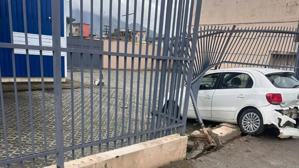 Gol branco destruído após atravessar faixas da BR-101 e colidir contra a fachada da empresa Metalosa, em José de Anchieta, na Serra.